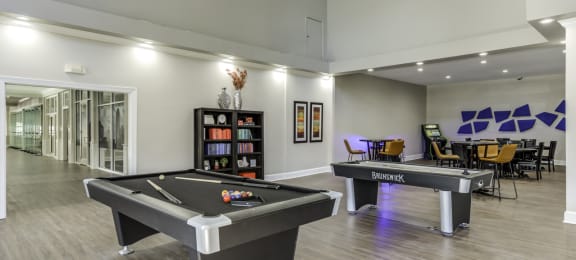 Community clubhouse with a pool table, air hockey table, poker tables and vintage arcade machine.