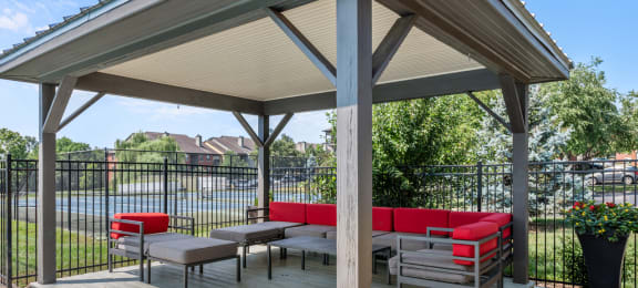 Outdoor pergola with lounge seating overlooking the community tennis courts