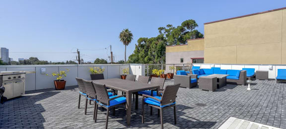 A rooftop deck at 4801 Shattuck featuring a stylish dining area and lounge space with grills.