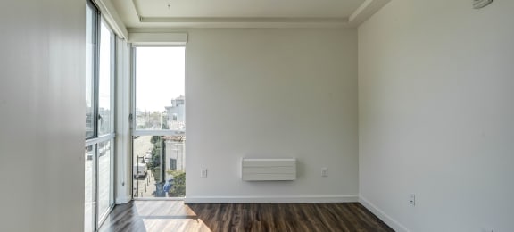 an empty living room with a heater on the wall