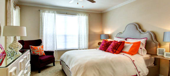 Spacious bedroom with walk-in closet and ceiling fan at Tuscany Apartments in Houston.