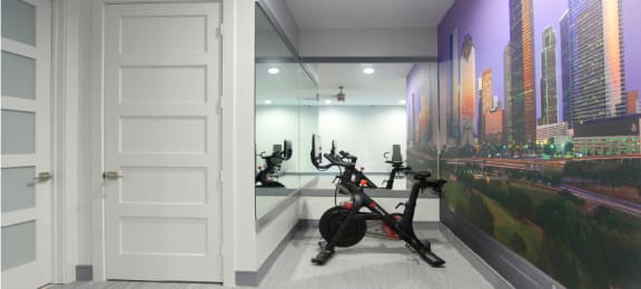 Newly remodeled Fitness Center open 24/7 with brand new Life Fitness equipment including 1 peloton bike, 4 resistance machines, 2 treadmills, 1 life cycle, 1 elliptical, full rack of free weights and dumbbells and water bottle refill fountain at Tuscany Apartments in Houston.