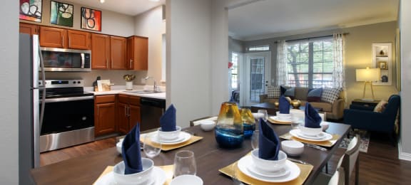 Luxury apartments with wood grain plank floors, dining room, u-shaped kitchen, 9-foot ceilings, gray colored walls, and built-in shelves, at Lenox Village Apartments in Lincoln, Nebraska