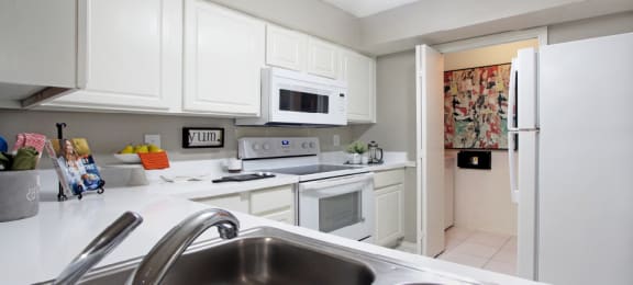 Bright white kitchen, spacious kitchen and full size and washer and dryer at Preston Village Apartments in North Dallas