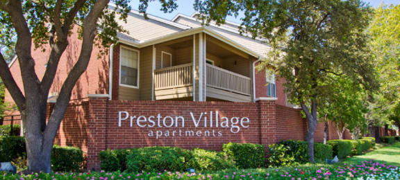 Luxury apartments in north Dallas with beautiful landscaping, scenic views, and red brick exteriors at Preston Village Apartments