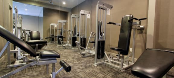 Luxury apartments with a fitness center in a gated community at Preston Village Apartments in North Dallas