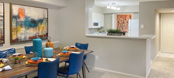 Spacious apartments with dining room and kitchen with white cabinets at Preston Village Apartments in north Dallas