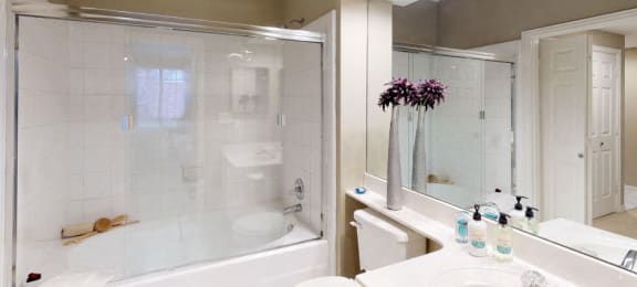 Luxury apartments with spacious bathrooms with glass showers, oval soaking tubs, and cultured marble vanities at Tuscany Gate Apartments in Houston.