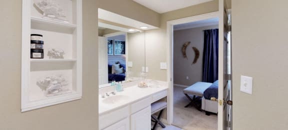 Luxury apartments with spacious bathrooms with glass showers, oval soaking tubs, built-in shelves, spacious linen closets, and cultured marble vanities at Tuscany Gate Apartments in Houston.