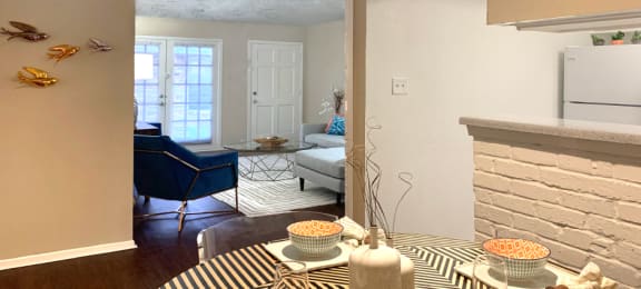 Spacious one and two bedroom floor plans with white brick accent walls and wood plank floors at Waters of Winrock Apartments in Houston.