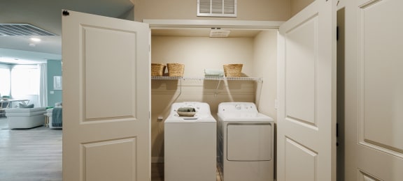 a washer and dryer closet in a laundry room with white doors at SYNC APARTMENT HOMES, Nevada, 89084
