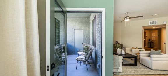 an open door leading into a living room with a patio and a dining room at SYNC APARTMENT HOMES, North Las Vegas