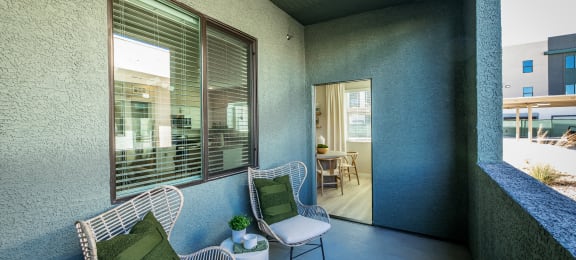 a balcony with two chairs and a table at SYNC APARTMENT HOMES, Nevada, 89084