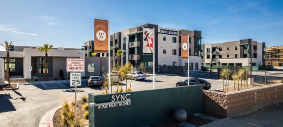 a building with a sign in front of a parking lot at SYNC APARTMENT HOMES, Nevada, 89084