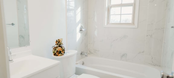 a white bathroom with a tub and a toilet