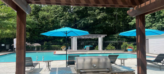 Place at Midway Douglasville GA a pergola with a grill and umbrellas overlooking a swimming pool