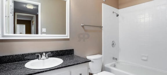 Fremont CA Apartments-Logan Park Apartments Bathroom With Large Tub With Square Tile And Dark Granite Sinktop