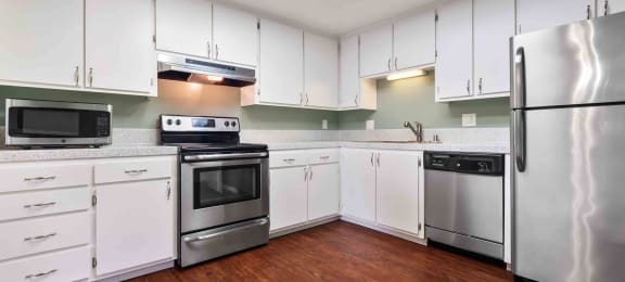 Apartments for Rent in Fremont CA - Logan Park - Spacious Kitchen with Wood-Style Flooring, Speckled Grey Countertops, White Cabinets, and Stainless Steel Appliances