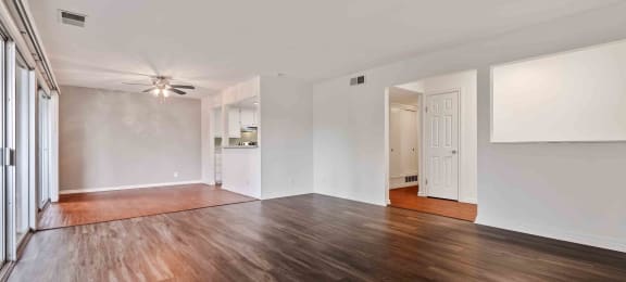 Two-Bedroom Apartments in Fremont, CA - Logan Park - Spacious Living Room with Sliding Glass Doors to Patio/Balcony, a Ceiling Fan, and Wood-Style Flooring.