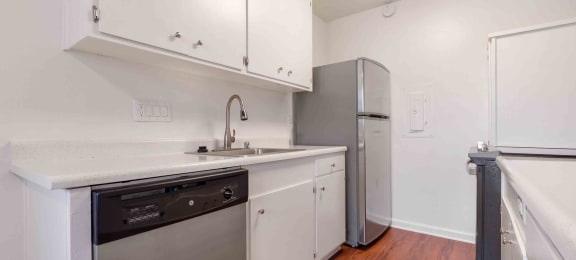 Apartments for Rent in San Lorenzo - Lorenzo Commons - Kitchen with Wood-Style Flooring, White Cabinets, Stainless-Steel Appliances, and Quartz-Style Countertops