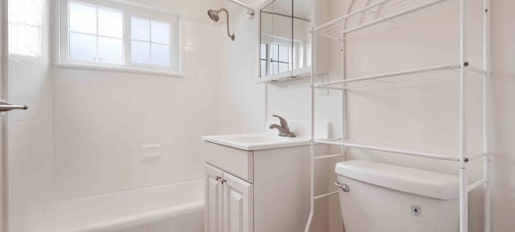 San Lorenzo Apartments - Lorenzo Commons - Bathroom with Wood-Style Flooring, Shower/Bathtub Combo, Towel Rack, and White Vanity