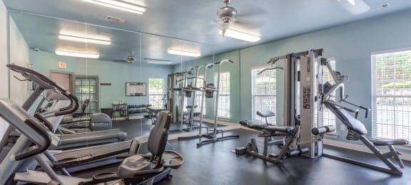 a gym with weights and cardio equipment at the estates apartments