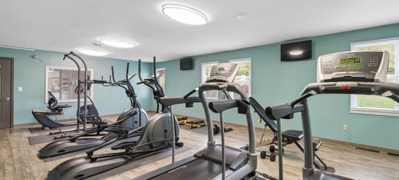 a gym with cardio machines and weights at apartment complex