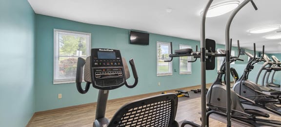 a gym with various machines at apartment community