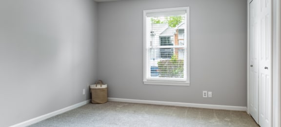 an empty room with a large window and a white door