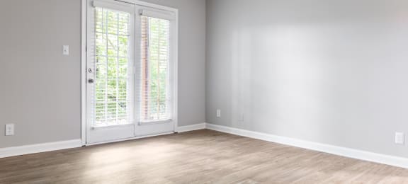 an empty room with white walls and wood floors