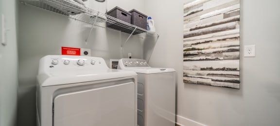 a washer and dryer in a laundry room with a shelf over the was