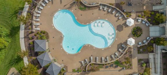 an overhead view of a swimming pool at a resort with umbrellas