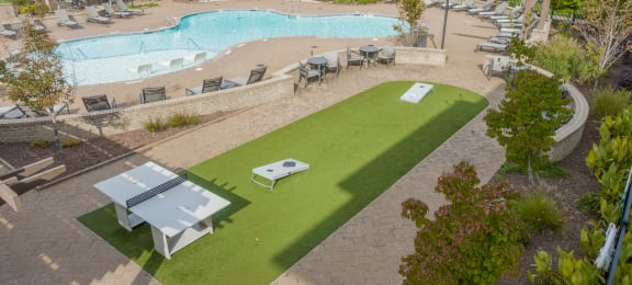 a view of a pool and a poolside patio with tables and umbrellas