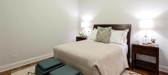 Bedroom with cozy bed and lights at Wells Place Apartments, Chicago, IL, 60607