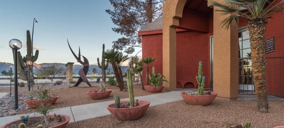 Front of building with large clay pots with cacti and view of mountains