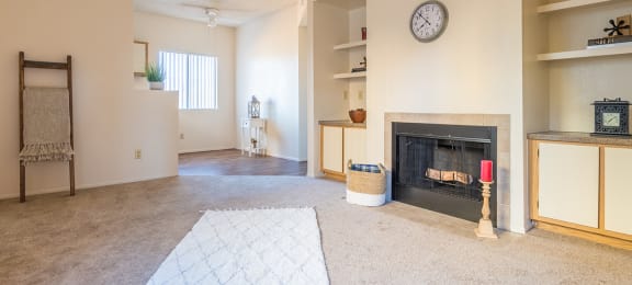 Open living room with fireplace and shelves with large window on sidewall