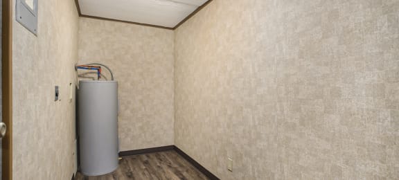 a small room with a water heater in the corner