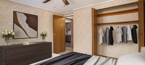 a bedroom with a bed and a ceiling fan and a closet