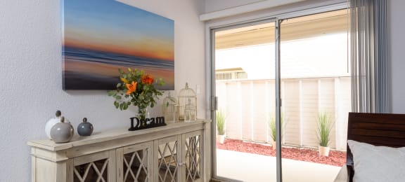 a bedroom with a large painting of a sunset on the wall