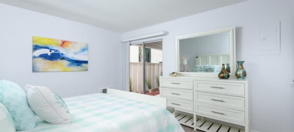 a bedroom with a bed and a dresser and a mirror