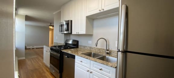 a kitchen with white cabinets and stainless steel appliances