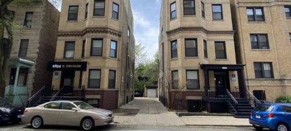 a view of the building from across the street with a car parked in front of it