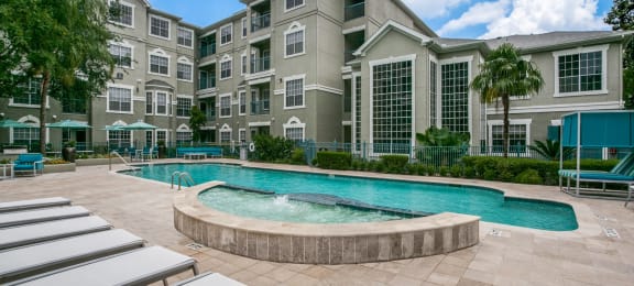 Townhomes for Rent in Houston, TX - The Maroneal - Resort Style Pool with Hot Tub, Lounge Seating, Palm Trees, and Greenery