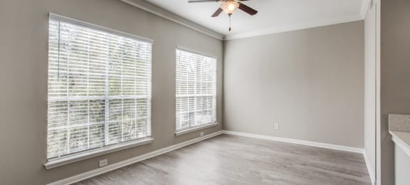 Apartments for Rent Houston - Open-Concept Living Room with Wood Flooring, Two Large Windows, and a Ceiling Fan