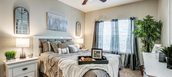 Three Bedroom Townhomes in Houston, TX - The Maroneal - Spacious Bedroom with Plush Carpet, a Large Window, and a Ceiling Fan