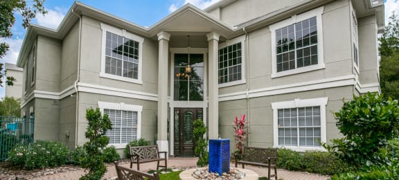 Apartments for Rent in Houston - Exterior View of The Maroneal Leasing Office With Outdoor Fountain, Benches and Lush Greenery