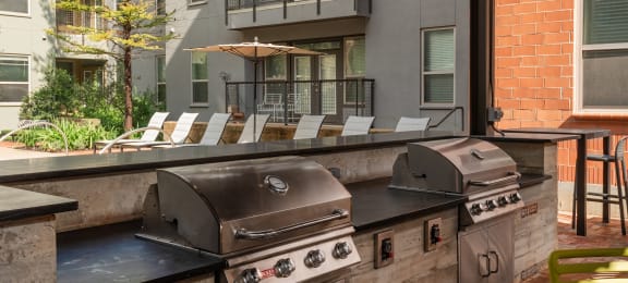 utdoor grill area with chairs and stainless steel appliances  at The Can Plant Residences at Pearl, San Antonio, TX