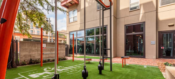A courtyard with grass and exercise equipment at The Can Plant Residences at Pearl, San Antonio, TX 78215and a white counter top  at The Can Plant Residences at Pearl, Texas, 78215
