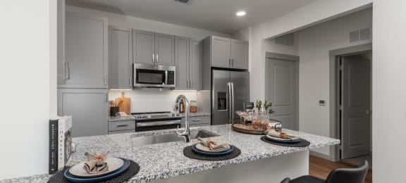 a kitchen with granite counter tops and a island with plates of food