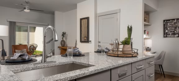 an open kitchen with granite counter tops and a sink